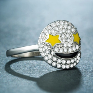 Gros plan d'une bague argentée avec un visage souriant rond et des yeux en étoile jaune