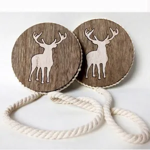 Pair of wooden magnetic curtain tiebacks with white reindeer silhouette and woven rope