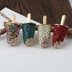 Detailed view of colorful rhinestone ice cream brooches set on a wooden surface