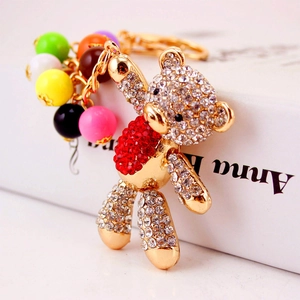 Golden rhinestone cartoon bear keychain with red body and colorful beads pendant