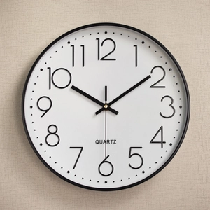 Modern 12-inch silent wall clock with black frame and 3D numeric display on beige wall