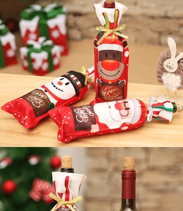 Close-up of festive Christmas wine bottle bags with Santa and snowman patterns