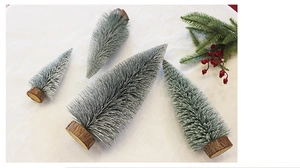 Detailed top view of four mini flocked Christmas trees in varying sizes with wooden bases