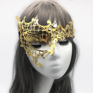 Detailed view of golden filigree metal mask with rhinestones on a mannequin head