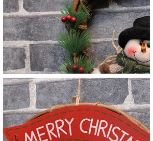 Close-up of Merry Christmas wooden plaque with pine needles and snowman decoration