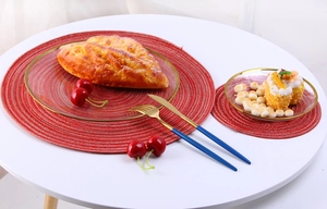 Close-up of red circular ramie woven placemats with spiral texture on a white table