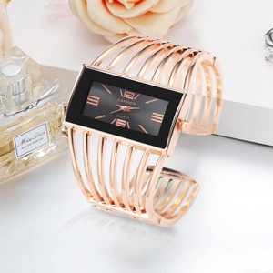 Detail of rose gold open cuff watch with hollow metal straps and black rectangular dial