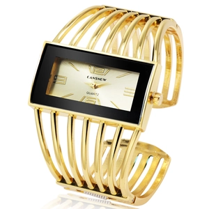 Detail of a golden cuff watch for women with hollowed-out strap and rectangular quartz dial
