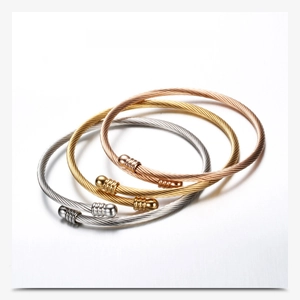 Detailed view of three-color cable wire bracelets in gold, silver and rose gold
