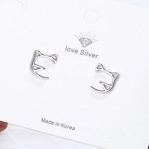 Minimalist silver cat ear studs in a hollow design on a clean display card