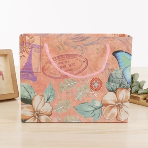 Détail du sac cadeau vintage Paris Tour Eiffel avec anse rose sur table en bois