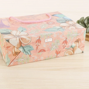 Sac cadeau en papier rose avec motif floral tour britannique et poignées en corde