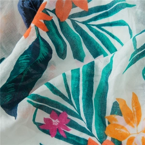 Detail of tropical palm leaf print on lightweight cotton linen scarf with soft texture