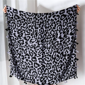 Detailed close-up of leopard print shawl with fringe edges and lightweight fabric