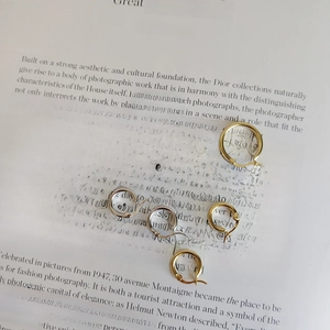 Artistic detail of gold and silver 925 sterling silver hoop earrings on a vintage book