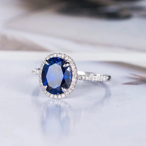 Elegant royal blue sapphire halo ring with sparkling pavé diamonds on a silver band