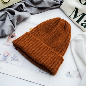 Detailaufnahme der warmen karamellfarbenen Strickmütze auf modischem Magazinhintergrund