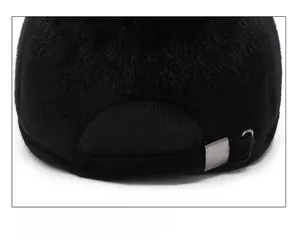 Detail of adjustable silver buckle and thick black faux fur texture on winter baseball cap