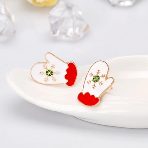 Detail view of festive red and green enamel glove earrings with golden snowflakes