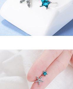 Macro detail of asymmetric blue star and starfish earrings showing mini size comparison