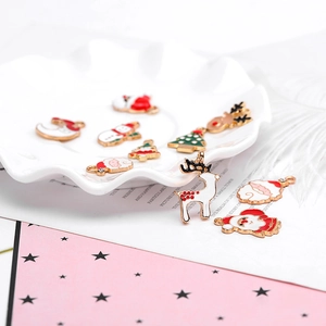 Detailed collection of festive enamel Christmas charms like reindeer and trees on a white plate
