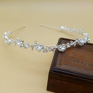 Detailed close-up of bridal headband featuring silver alloy flower with pearls and crystals