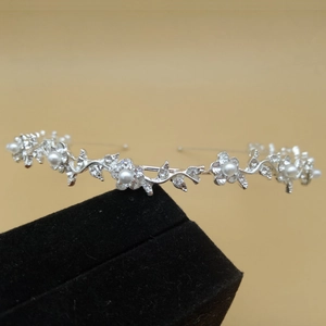 Detailed close-up of bridal headband with silver flower petals, pearls and rhinestones