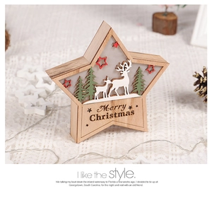 Close-up of star-shaped wooden Christmas ornament with reindeer, LED light, and Merry Christmas text