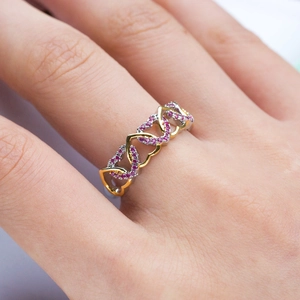 Detailed close-up of a two-tone heart-shaped ring with pavé set purple cubic zirconia