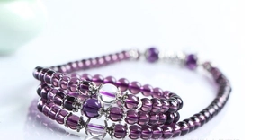 Macro shot of multi-layer purple glass bead bracelet with silver spacers and glossy finish