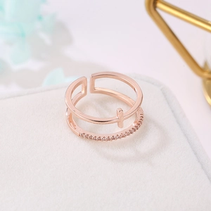 Macro detail of rose gold double-layer open ring with cross design and zircon inlay