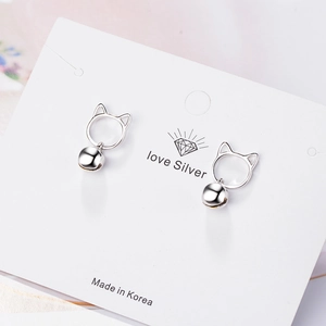 Silver cat stud earrings with dangling bell charms on a jewelry card 45-degree view