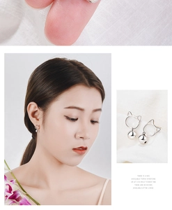 Detail of silver cat stud earrings with dangling bells shown on model and close-up