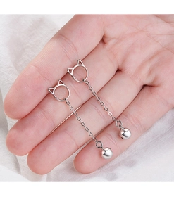 Detailed view of silver cat ear dangle earrings with bells on a soft white background