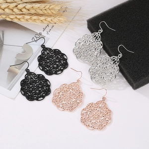 Detailed close-up of hollow mandala drop earrings in black, silver and rose gold finish