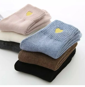 Detail view of six pairs of winter socks with gold heart embroidery in multiple colors