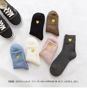 Flat lay of warm cotton socks with gold heart embroidery in six various earthy colors