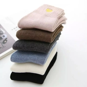 Close-up of colorful crew socks with gold heart embroidery in six assorted colors