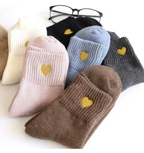 Close-up of colorful knitted cotton socks with elegant gold heart embroidery details