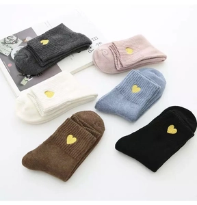 Detailed view of six pairs of cotton crew socks with gold heart embroidery and ribbed cuffs