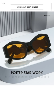 Detail of irregular black frame sunglasses with vibrant orange lenses and wave-shaped temples
