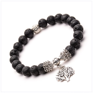 Detail of lava rock beads bracelet with silver tree of life charm on white background