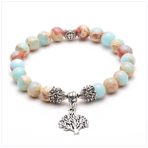 Detailed close-up of tree of life charm and emperor stone beads on yoga bracelet