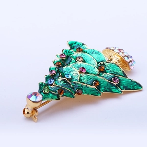 Macro detail of Christmas tree brooch with green enamel and multi-color rhinestones