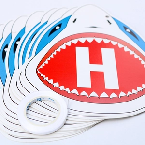 Detail of blue shark paper masks with letter H print and double-sided adhesive tape