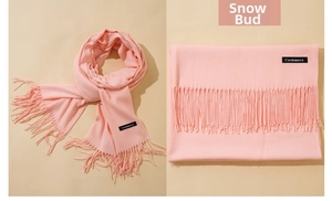 Detail of light pink cashmere-like scarf showing fringe and woven cashmere label
