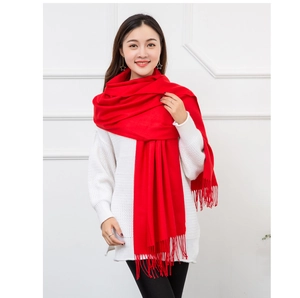 Detail of red faux cashmere scarf featuring soft texture and stylish tassel fringes