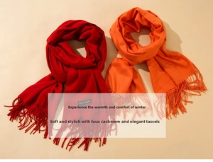 Detail of red and orange cashmere-feel scarves with soft fringe texture for winter