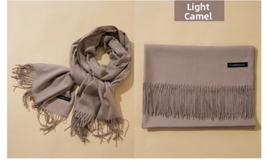 Detail of light camel cashmere scarf showing soft texture and fine fringe tassels