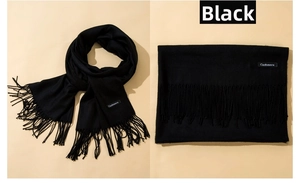 Detail of black cashmere-like scarf showing texture, long fringe tassels and label
